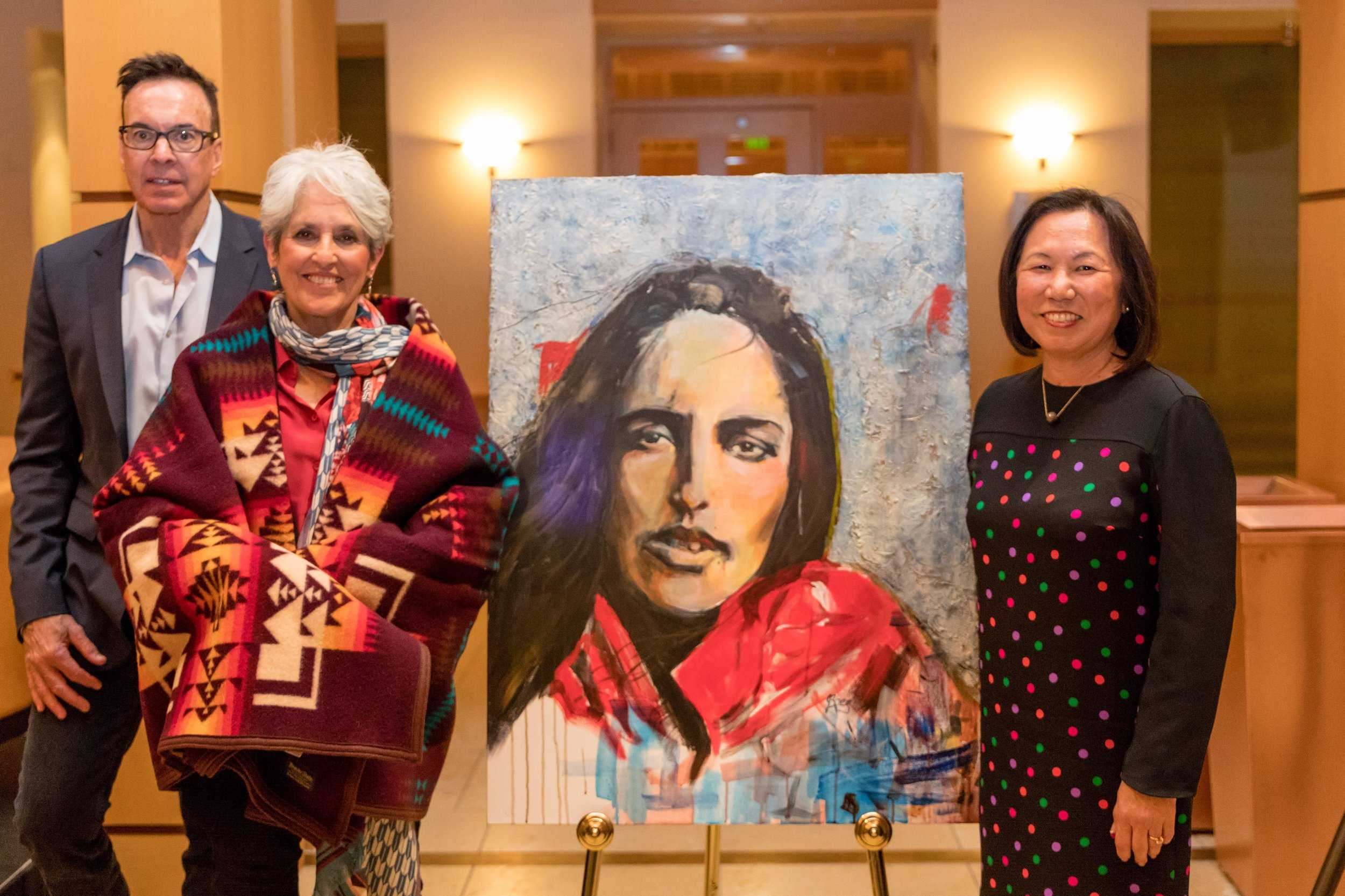 Tribal Chairman Greg Sarris, (left) Joan Baez and Judy Sakaki (right) pose in front of one of Baez’s paintings as part of her ‘Mischief Makers’ series.&nbsp;