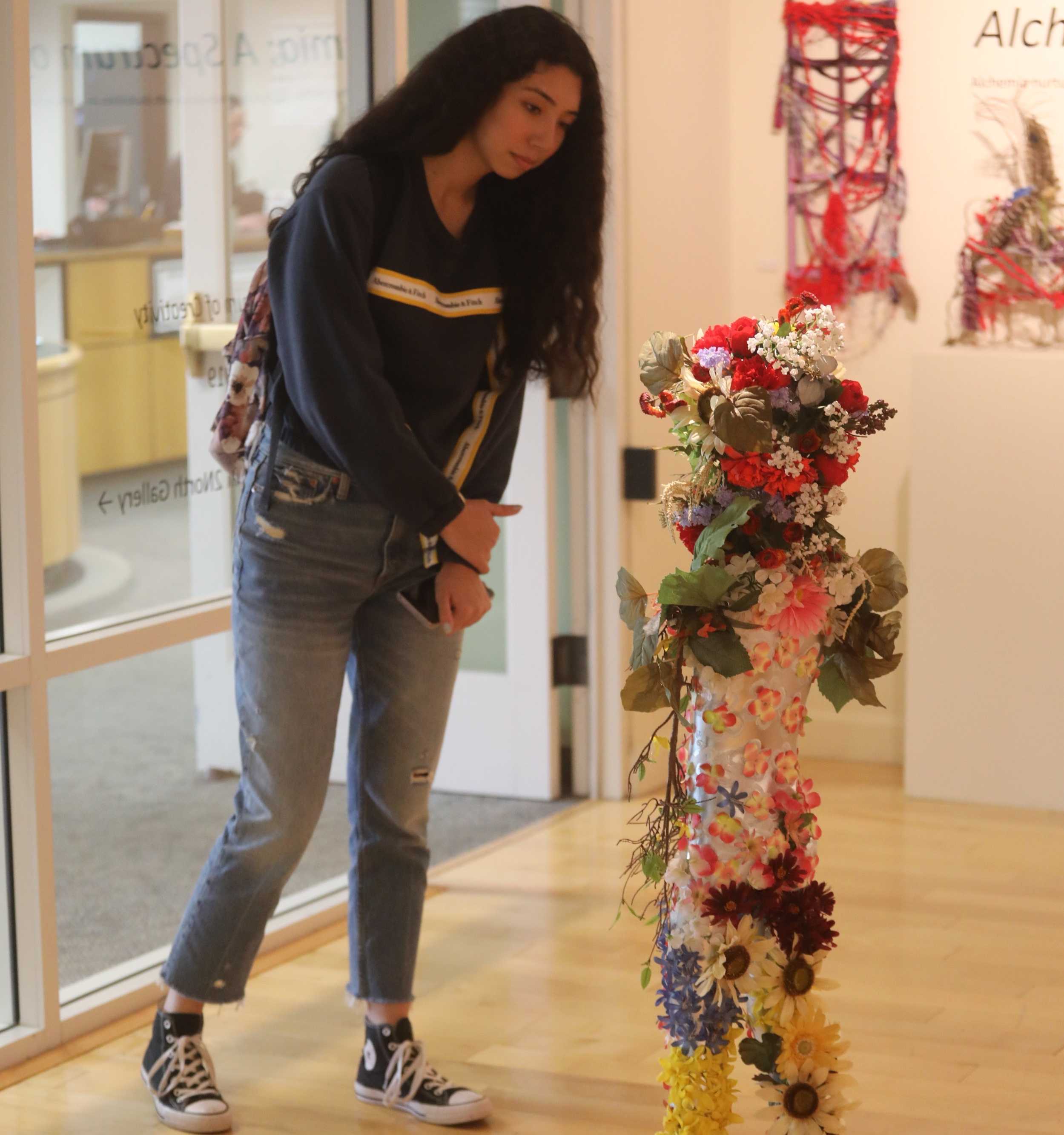 Junior Ava Garcia looks a unique piece of art at Alchemia: A Spectrum of Creativity in Sonoma State’s Art Gallery. STAR // Jessica Rivera
