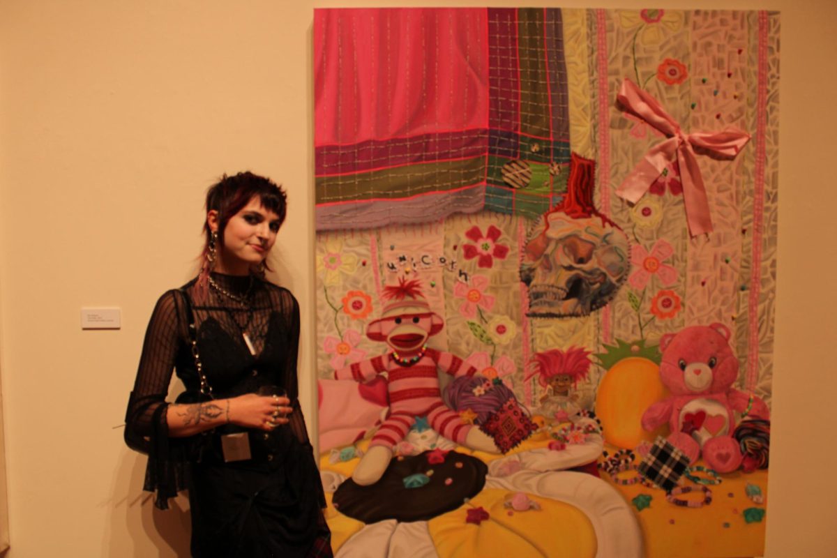 Ash Gregorio beside one of her paintings at the BFA Exhibition