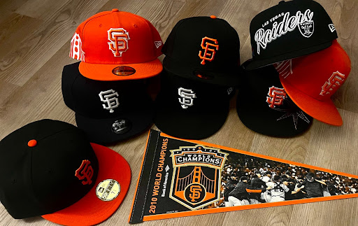 A bold display of Bay Area pride: San Francisco Giants and Las Vegas Raiders hats surround a 2010 World Series Champions pennant.