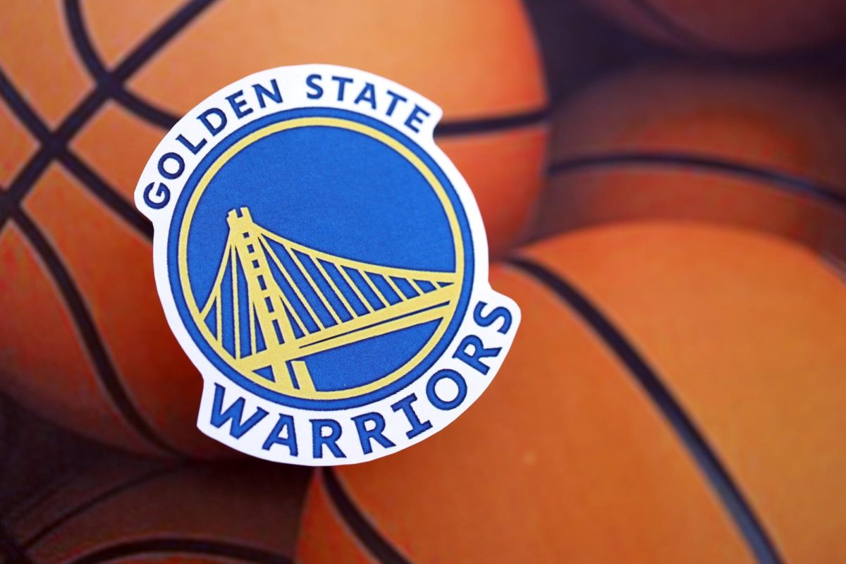 The Golden State Warriors logo over a pile of basketballs.