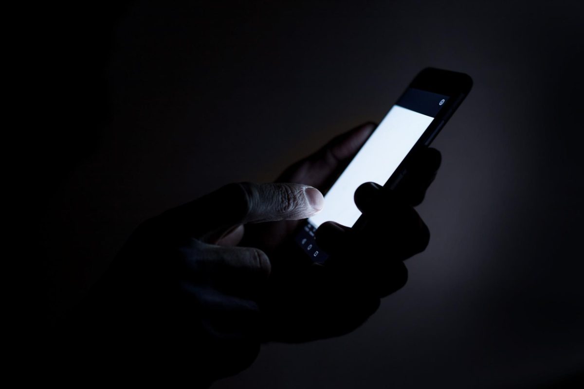 A phone screen in a dark room.